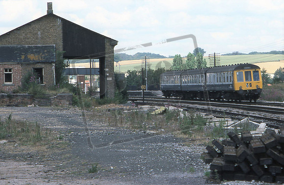 Hungerford Goods Shed (Cat No 209-20) With DMU L587 passing. 22-07-76 David Canning